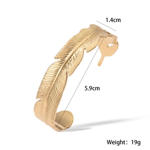 Macro view of 18K gold plated feather cuff bangle with 1.4cm width and 5.9cm diameter