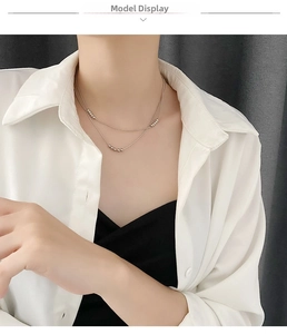Detail of silver double-layered necklace with polished beads on a female model neck