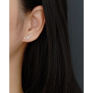Detailed close-up of a sterling silver ear cuff with sparkling zircon stones on model
