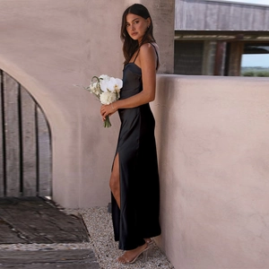 Detail of elegant black satin dress with thin straps and a high side slit feature
