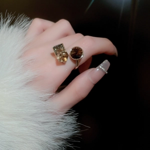Close-up of gold-plated open ring with rectangle and round amber cubic zirconia stones