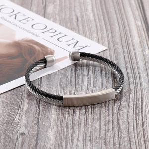 Detail of twisted cable cuff bracelet with brushed metal plate and open-end cylindrical caps