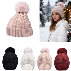 Close-up of thick cable knit texture and fluffy faux fur pompom on winter beanies