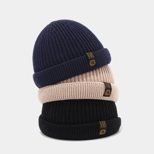 Trois bonnets en maille empilés en bleu marine, kaki et noir avec étiquettes