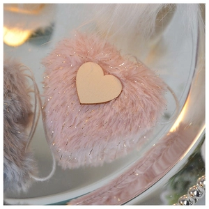 Close-up of pink plush heart ornament with wooden center patch for Christmas decoration