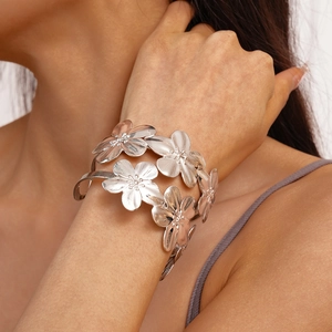 Detail of silver layered flower cuff bracelet with brushed metallic texture and open design