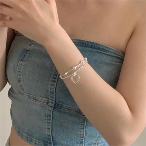 Detail view of 925 silver beaded bracelet with large transparent heart pendant on wrist