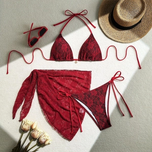 Detailed flat lay of red lace 3-piece bikini set with matching mesh sarong and sunhat