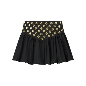 Detail of black skirt featuring V-shaped waistline and golden circular sequin embellishments