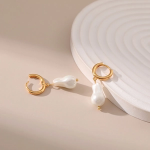 French style baroque pearl drop earrings with elegant gold hoops on minimalist display