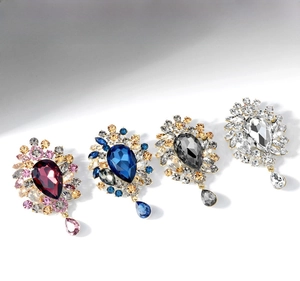 Detailed close-up of crystal teardrop brooches in burgundy, blue, gray, and white