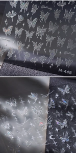 Macro view of holographic butterfly nail art stickers with laser silver floral patterns