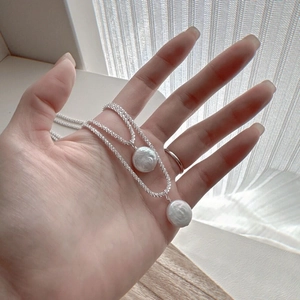 Detail of double-layer S925 silver necklace featuring two natural baroque pearl pendants