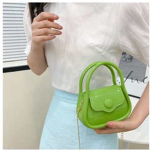 Mini lime green jelly bag with gold chain strap held by a model in a modern room
