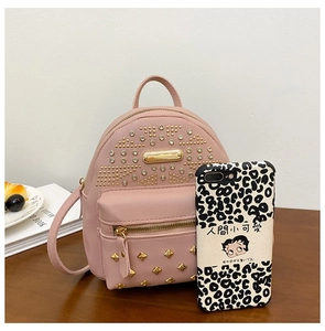 Detailed view of pink mini backpack featuring golden studs and rhinestone embellishments