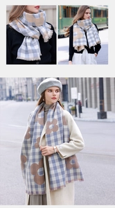 Close-up of blue and beige checkered scarf with floral patterns and tassel details