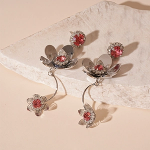 Silver flower tassel drop earrings with pink cubic zirconia stones on white stone base