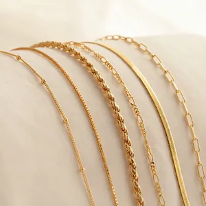 Collection of six 18K gold plated stainless steel chain styles on soft cream fabric
