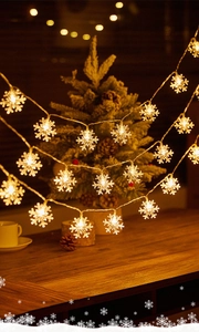 Close-up of LED snowflake fairy lights emitting warm white glow for Christmas decor