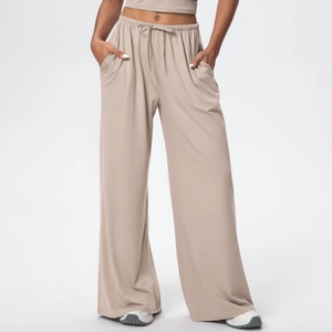 Detailed view of elastic drawstring waistband and side pockets on beige wide-leg pants
