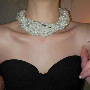 Close-up of layered pearl choker necklace with rhinestone accents on a model's neck