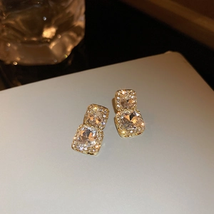 Elegant gold double square earrings with sparkling crystals shown in a macro perspective