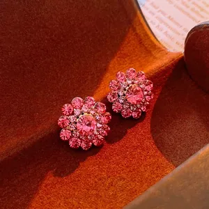 Sparkling pink flower stud earrings with rhinestones on a brown velvet jewelry box base