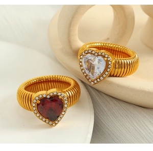 Detailed view of two gold stretch rings featuring red and white heart-shaped gemstones