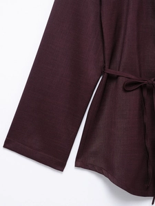 Detail of deep purple satin shirt showing long sleeve cuffs and waist tie texture