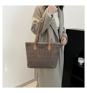 Large vintage plaid tote bag with brown leather handles worn over the shoulder