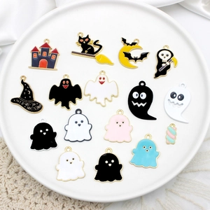 Flat lay of colorful enamel Halloween charms including ghost, black cat, and wizard hat detail