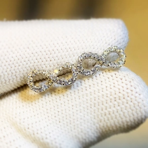 Silver infinity ring featuring sparkling pavé crystals shown on a gloved finger