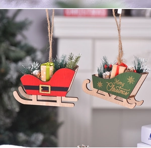 Detail of green wooden Christmas sleigh hanging ornament with pine needles and mini gift box
