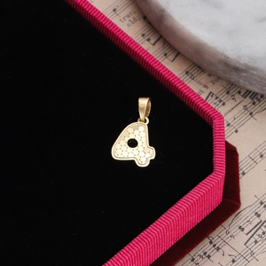 Detail shot of golden number 4 pendant with honeycomb texture in a red velvet jewelry box