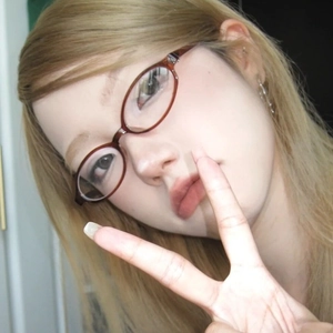 Retro oval reddish-brown frame glasses for women in a vintage minimalist selfie style