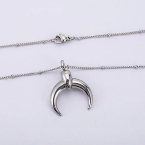 Polished silver crescent moon pendant necklace with delicate bead chain on white background