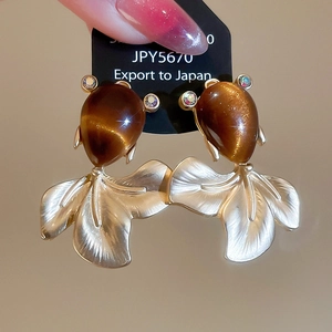 Macro shot of resin goldfish earring with cat-eye effect and sparkling rhinestones