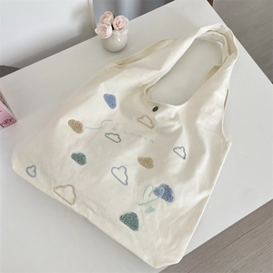 Close-up of colorful cloud towel embroidery and metal snap on off-white canvas tote