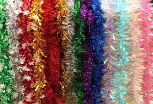 Detailed view of colorful Christmas tinsel garlands with white snowflake accents