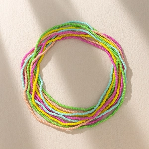 Bohemian colorful seed bead body chain with vibrant multilayered beads on textured stone