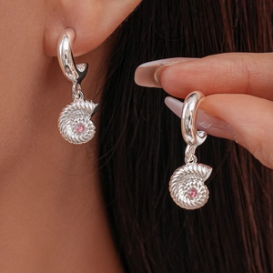 Detailed close-up of nautilus drop earrings with silver finish and pink zircon stones
