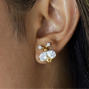 Close-up of 18K gold-plated bee earring with white cubic zirconia wings on model's ear