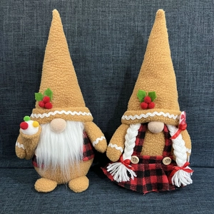 Close-up of gingerbread Christmas gnomes with faux fur beards and holly berry accents