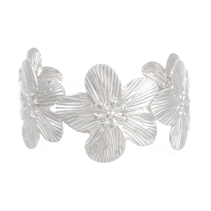 Macro shot of silver textured flower cuff bracelet with detailed metal petal craftsmanship