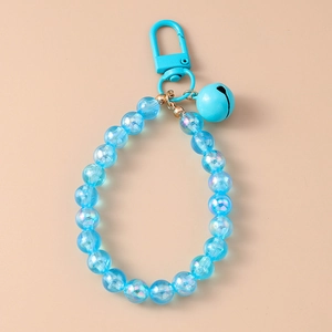 Detail of blue beaded keychain with transparent resin beads and matching metal bell charm