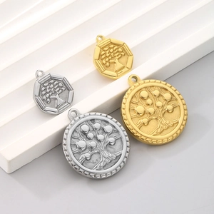 Detail of tree of life pendants in gold and silver, hexagonal and round metal charms