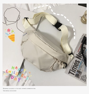 Flat lay of off-white minimalist nylon chest bag with black buckle on aesthetic background