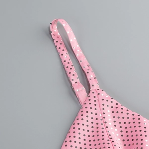 Détail d'une robe rose à bretelles avec des pois scintillants en paillettes argentées
