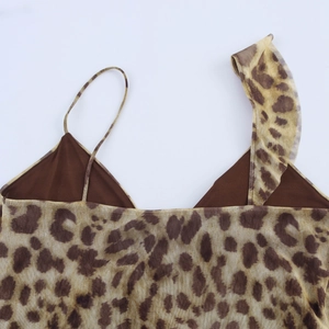 Dettaglio ravvicinato del top in mesh leopardato con spalline asimmetriche e volant