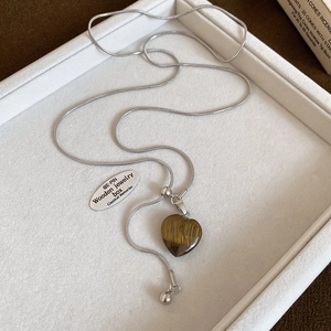 Detail of tiger eye heart pendant on silver snake chain with adjustable slider